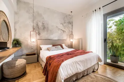 a bedroom with a large bed and a large window at Tree Olive Athens in Athens