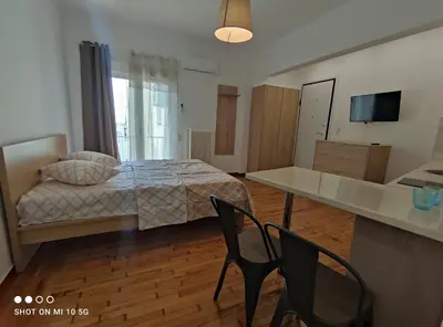 a bedroom with a bed and a desk and chairs at Studio in the heart of Athens !!! in Athens