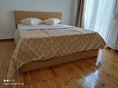 a bed with a brown comforter and two pillows at Studio in the heart of Athens !!! in Athens
