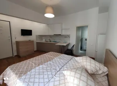 a bedroom with a large bed and a kitchen at Studio in the heart of Athens !!! in Athens
