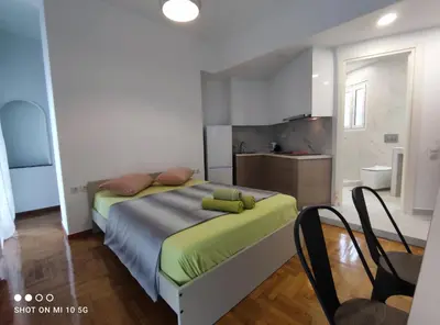 a bedroom with a large bed and a kitchen at Studio in the heart of Athens !!! in Athens