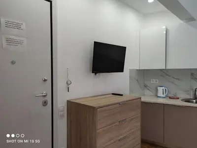 a kitchen with a tv on the wall and a counter at Studio in the heart of Athens !!! in Athens