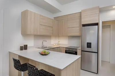 a kitchen with wooden cabinets and a bowl of fruit on a counter at THIRAMENOUS RESIDENCE in Athens