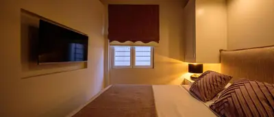 a bedroom with a bed with a television and a window at THIRAMENOUS RESIDENCE in Athens