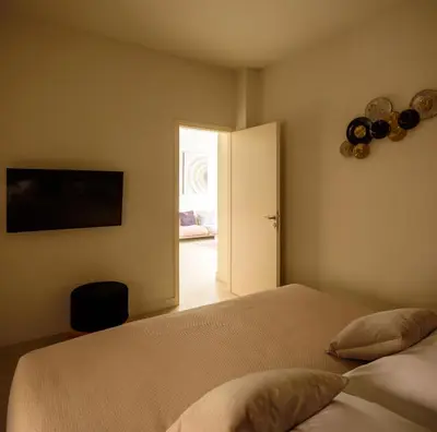 a bedroom with a bed and an open door at THIRAMENOUS RESIDENCE in Athens