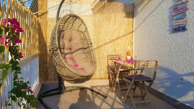 a porch with a hammock on a balcony with a table at WOW Penthouse Boutique in the heart of Historical Center in Athens