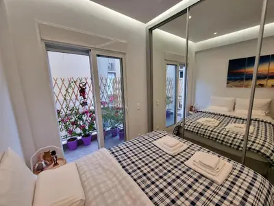 a bedroom with two beds and a mirror at WOW Penthouse Boutique in the heart of Historical Center in Athens