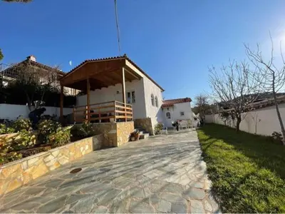 a house with a stone walkway in front of a yard at Lagonisi MAGIC HOME RELAXATION in Kalívia Thorikoú