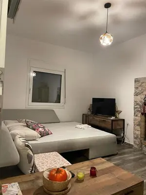 a living room with a bed and a table at Lagonisi MAGIC HOME RELAXATION in Kalívia Thorikoú