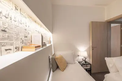 a bedroom with a white bed and a wall with posters at Ports Crossroad E in Piraeus