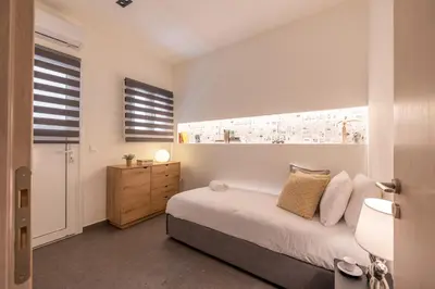 a bedroom with a bed and a dresser and a window at Ports Crossroad E in Piraeus
