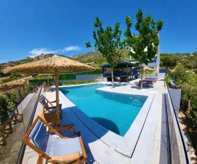 a swimming pool with chairs and an umbrella at ''Stergiou Luxury Apartments'' με κοινη πισινα in Saronida