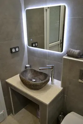 a bathroom with a stone sink and a mirror at ''Stergiou Luxury Apartments'' με κοινη πισινα in Saronida
