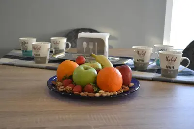 a plate of fruit on a table with cups at ''Stergiou Luxury Apartments'' με κοινη πισινα in Saronida