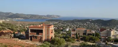 a building on the side of a hill with a city at ''Stergiou Luxury Apartments'' με κοινη πισινα in Saronida