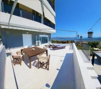 a patio with a table and chairs on a building at ''Stergiou Luxury Apartments'' με κοινη πισινα in Saronida