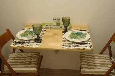 a wooden table with two plates and glasses on it at Kolonaki. Luxurious Studio in Athens