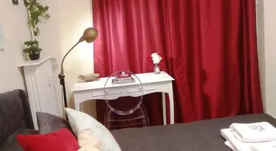 a desk with a phone in front of a red curtain at Kolonaki. Luxurious Studio in Athens