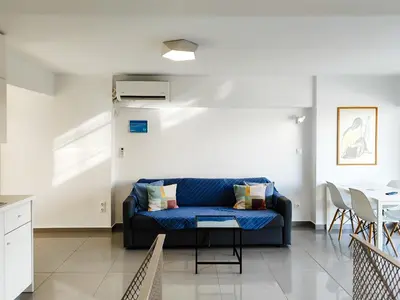 a living room with a blue couch and a table at KYMA Apartments Athens 19 in Athens
