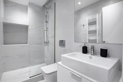 a white bathroom with a sink and a shower at Central Boutique Apartment A1 in Athens