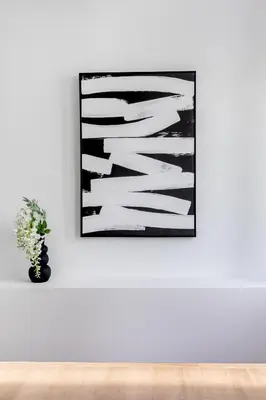 a picture on a white wall with a vase with a plant at Central Boutique Apartment A2 in Athens