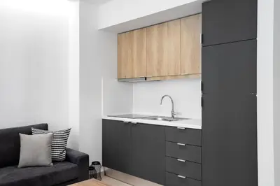 a black kitchen with a sink and a couch at Central Boutique Apartment A2 in Athens