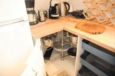 a kitchen counter with a dishwasher under a wooden counter top at Lovely apartment in Plaka in Athens