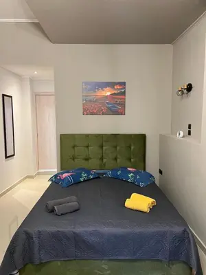 a bedroom with a large bed with two pillows on it at Johns Cozy apartments -10 min from Athens Airport Self Check-In! in Spáta