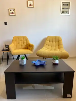 two yellow chairs and a coffee table in a room at Johns Cozy apartments -10 min from Athens Airport Self Check-In! in Spáta