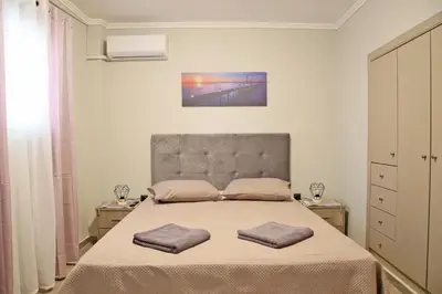 a bedroom with a bed with two pillows on it at Johns Cozy apartments -10 min from Athens Airport Self Check-In! in Spáta