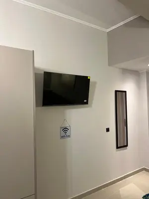 a flat screen tv on the wall of a room at Johns Cozy apartments -10 min from Athens Airport Self Check-In! in Spáta