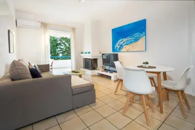 a living room with a couch and a table at Del Mar Luxury Apartment 30m From The Beach in Porto Rafti