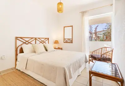 a bedroom with a bed and a chair and a window at Del Mar Luxury Apartment 30m From The Beach in Porto Rafti