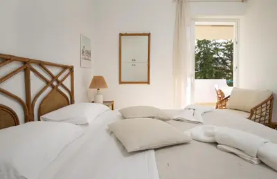 two white beds in a room with a window at Del Mar Luxury Apartment 30m From The Beach in Porto Rafti