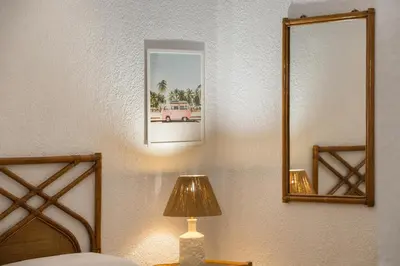 a bedroom with a bed with a lamp and a mirror at Del Mar Luxury Apartment 30m From The Beach in Porto Rafti