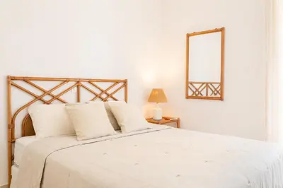 a bedroom with a white bed and a mirror at Del Mar Luxury Apartment 30m From The Beach in Porto Rafti