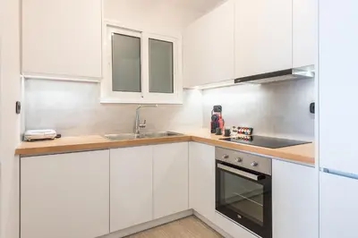 a white kitchen with white cabinets and a sink at Petraki Residence 1bdr Apt with balcony 1 min from Ermou str in Athens