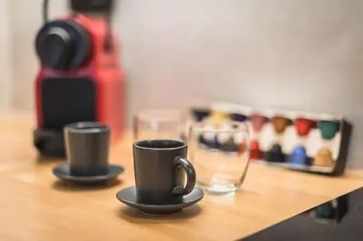 two coffee cups sitting on a wooden table at Petraki Residence 1bdr Apt with balcony 1 min from Ermou str in Athens