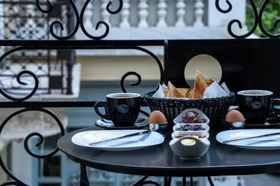 a table with two cups of coffee and a basket of food at Philia Boutique Hotel in Athens