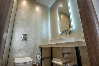 a bathroom with a sink and a toilet and a mirror at Philia Boutique Hotel in Athens