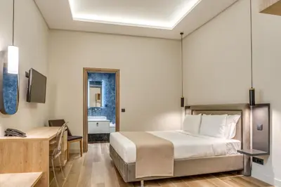 a bedroom with a bed and a desk and a sink at Philia Boutique Hotel in Athens