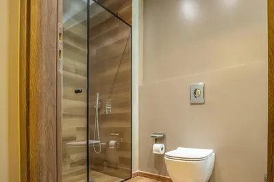 a bathroom with a toilet and a glass shower at Philia Boutique Hotel in Athens