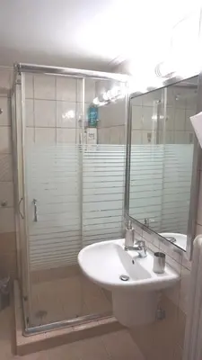 a bathroom with a sink and a shower with a mirror at A few steps away from Syntagma and Plaka by Athenian Homes in Athens