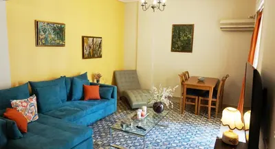 a living room with a blue couch and a table at A few steps away from Syntagma and Plaka by Athenian Homes in Athens