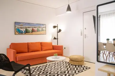 a living room with an orange couch and a table at Cozy Apartment in Central Athens - Sleeps 5 in Athens