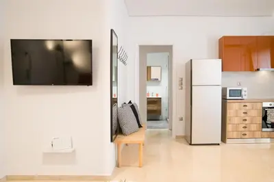 a kitchen with a white refrigerator and a wooden chair at Cozy Apartment in Central Athens - Sleeps 5 in Athens