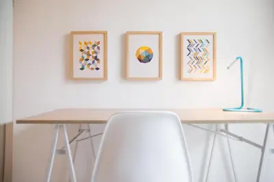 a table with three framed paintings on a wall with a chair at Cozy Apartment in Central Athens - Sleeps 5 in Athens