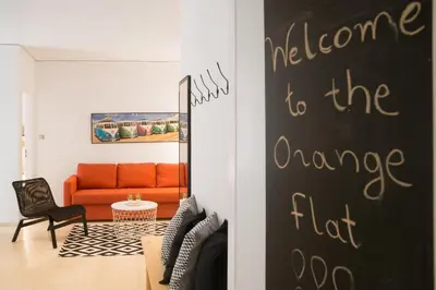 a living room with an orange couch and a black wall at Cozy Apartment in Central Athens - Sleeps 5 in Athens