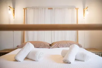 a white bed with towels on it with a window at Cozy Apartment in Central Athens - Sleeps 5 in Athens