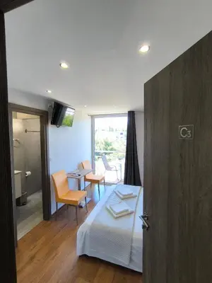 a bedroom with a bed and a table and chairs at Peania Domus in Paianía